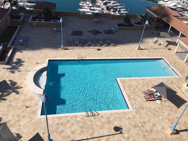 view of swimming pool featuring a patio area and a water view