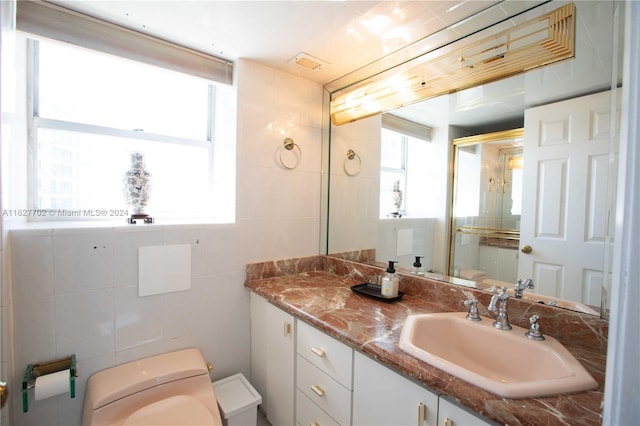 bathroom featuring tile walls, vanity, and toilet