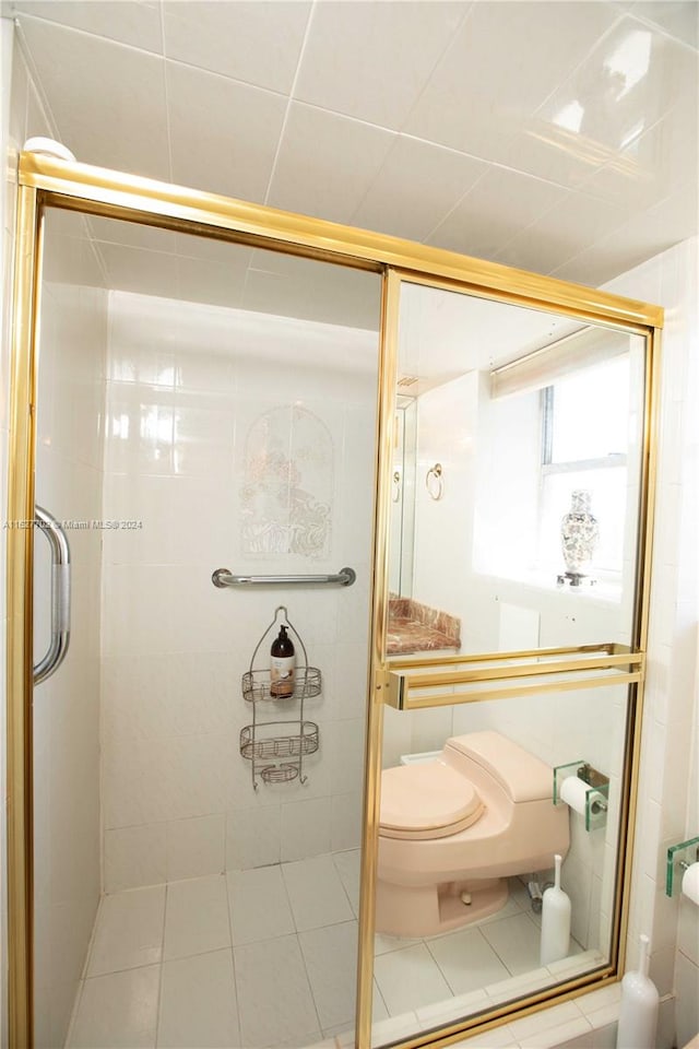 bathroom featuring tile patterned floors, toilet, and walk in shower