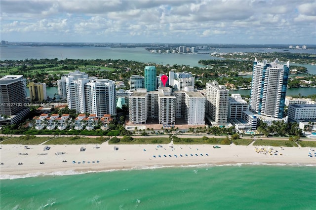 birds eye view of property featuring a beach view and a water view