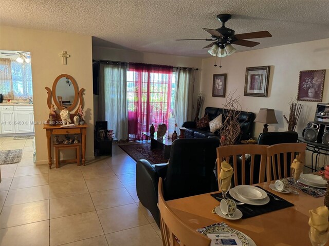 tiled dining area with sink, a textured ceiling, and ceiling fan