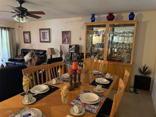 dining room featuring ceiling fan, tile patterned floors, and a textured ceiling