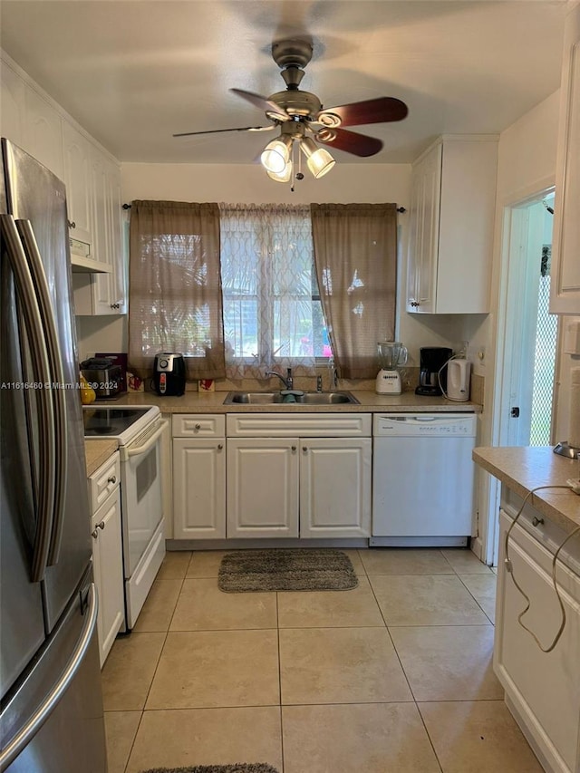 kitchen with sink, white appliances, light tile patterned floors, ceiling fan, and white cabinets