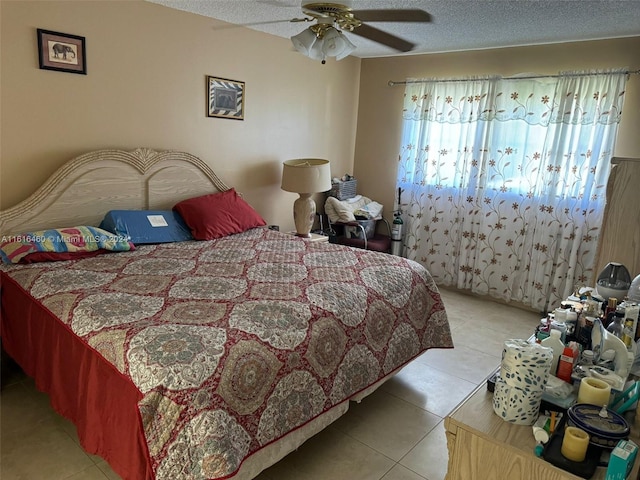 tiled bedroom featuring ceiling fan and a textured ceiling