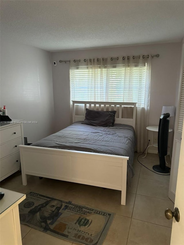 bedroom featuring light tile patterned floors and a textured ceiling