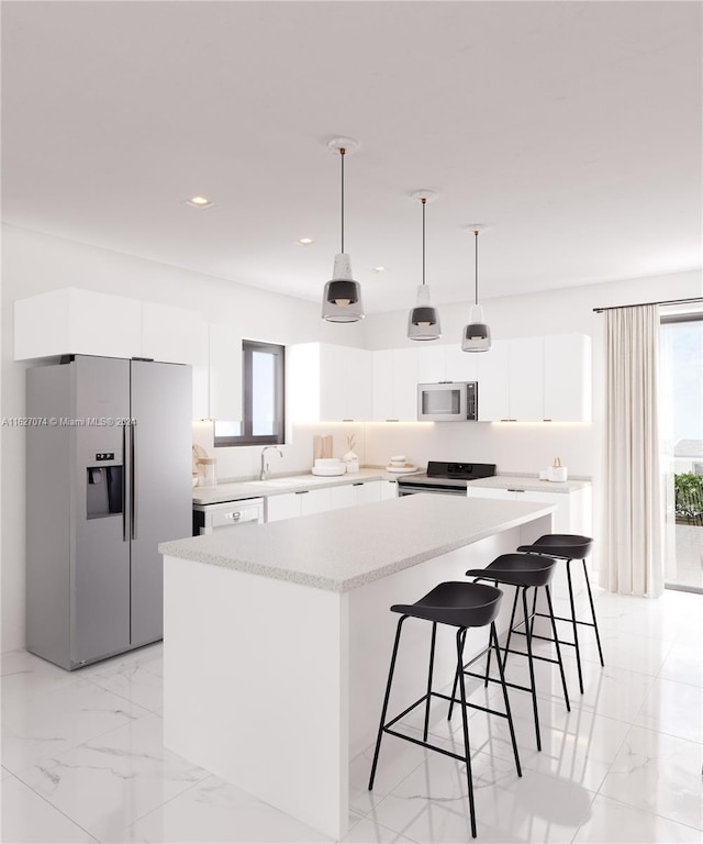 kitchen featuring white cabinetry, a center island, a healthy amount of sunlight, and stainless steel appliances