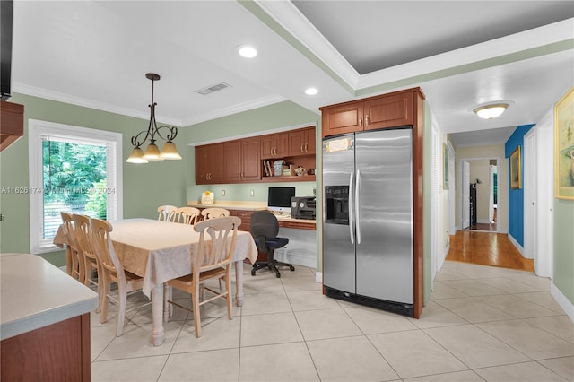 kitchen featuring stainless steel fridge with ice dispenser, hanging light fixtures, light wood-type flooring, and crown molding