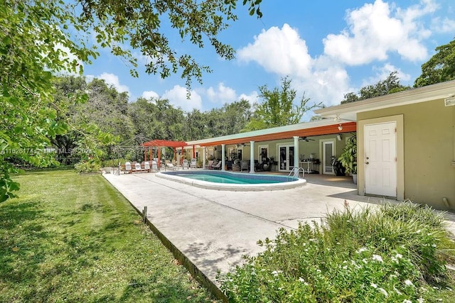 view of pool featuring ceiling fan, a lawn, a patio, and french doors