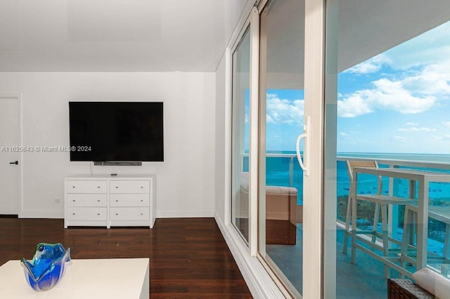 living room with dark hardwood / wood-style floors and a water view