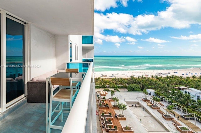 balcony featuring a water view and a view of the beach