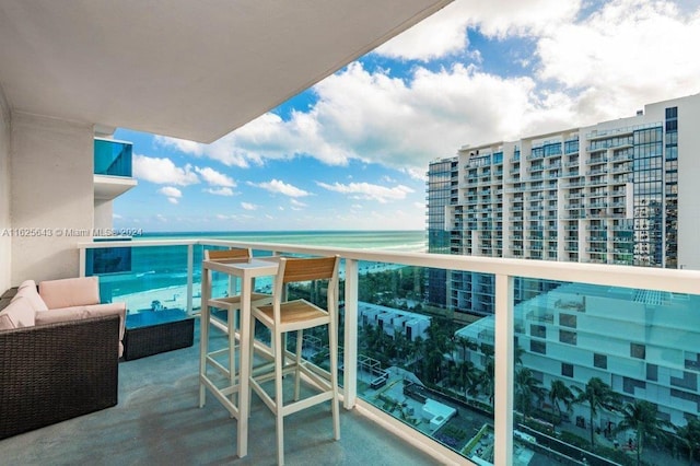 balcony featuring outdoor lounge area and a water view