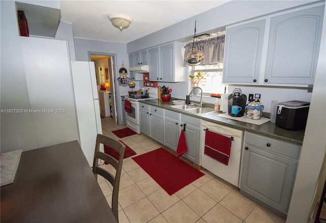 kitchen featuring gray cabinetry, sink, light tile patterned floors, and white appliances