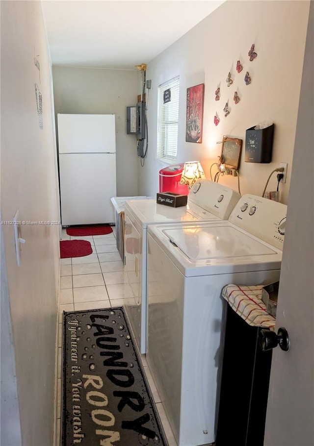 laundry room with light tile patterned flooring, electric panel, and washer and dryer