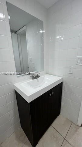 bathroom featuring tile walls, tile patterned flooring, and vanity