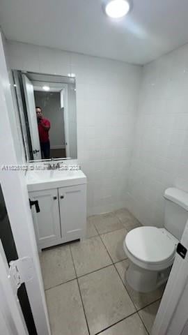 bathroom featuring tile walls, tile patterned floors, vanity, and toilet