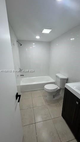 full bathroom featuring tiled shower / bath combo, vanity, toilet, and tile patterned floors