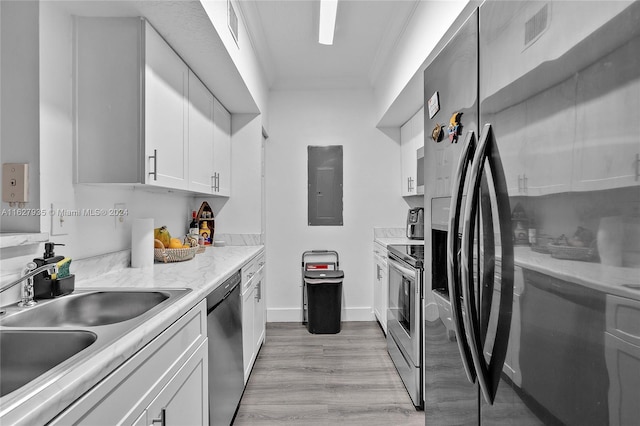 kitchen featuring sink, ornamental molding, white cabinetry, light hardwood / wood-style flooring, and appliances with stainless steel finishes