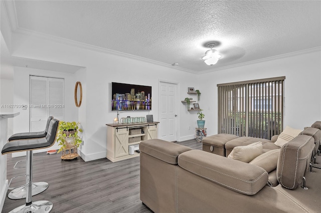 living room with ornamental molding, hardwood / wood-style flooring, and a textured ceiling