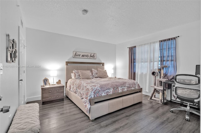 bedroom with hardwood / wood-style floors and a textured ceiling