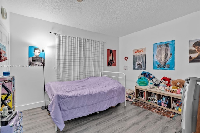 bedroom featuring light hardwood / wood-style floors and a textured ceiling