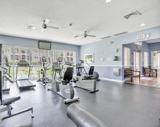 gym featuring ceiling fan, a wealth of natural light, and a textured ceiling