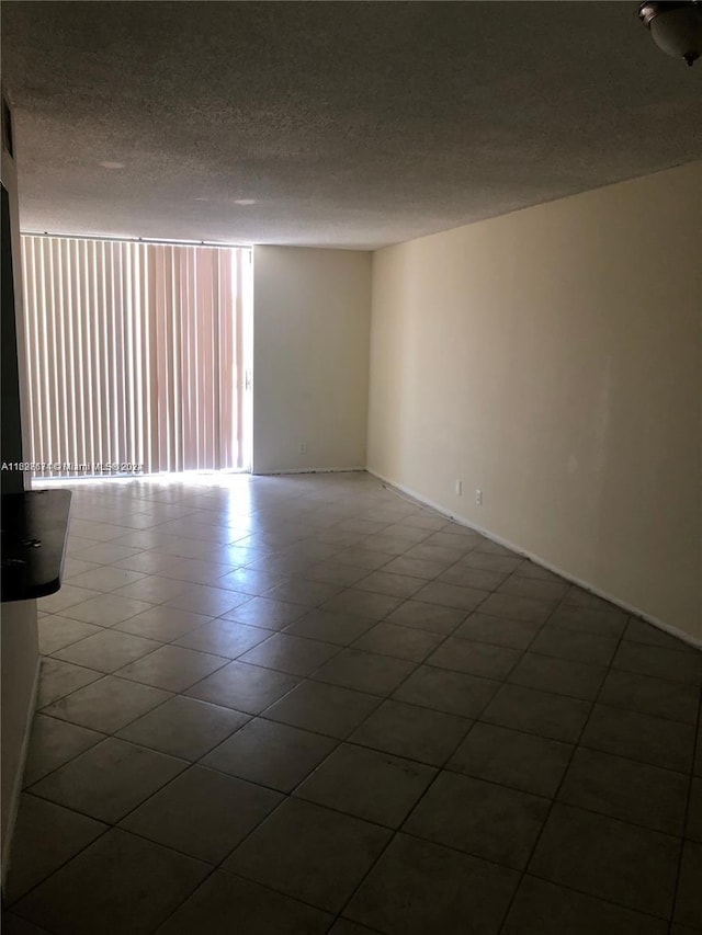 tiled spare room with a textured ceiling