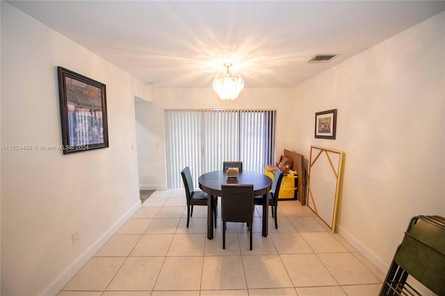 tiled dining area with an inviting chandelier