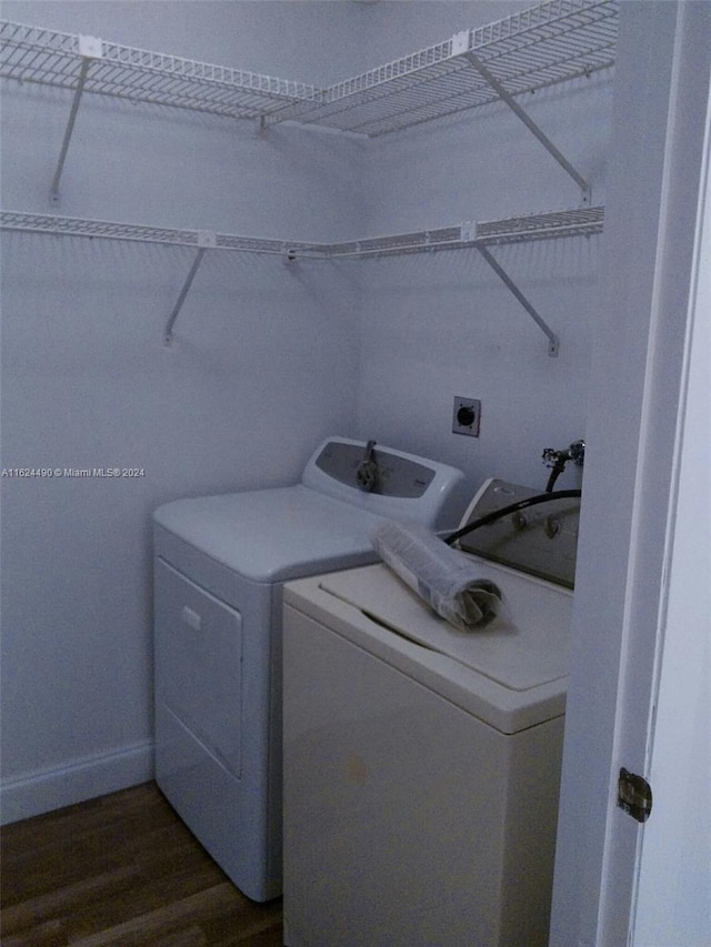 clothes washing area featuring dark wood-type flooring and separate washer and dryer