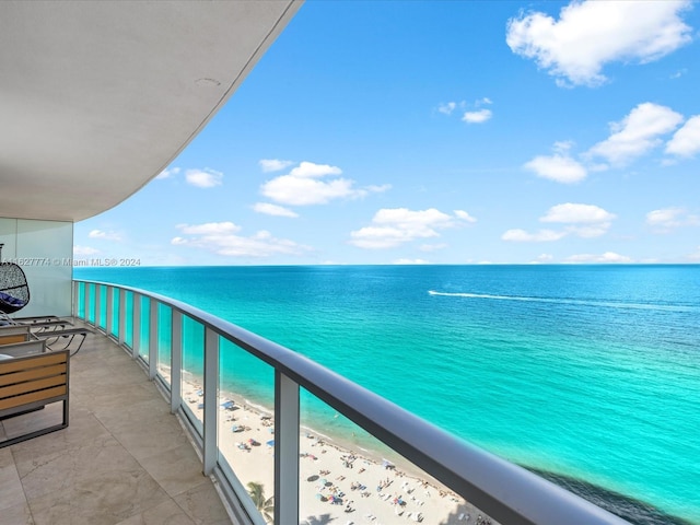 balcony featuring a water view and a beach view