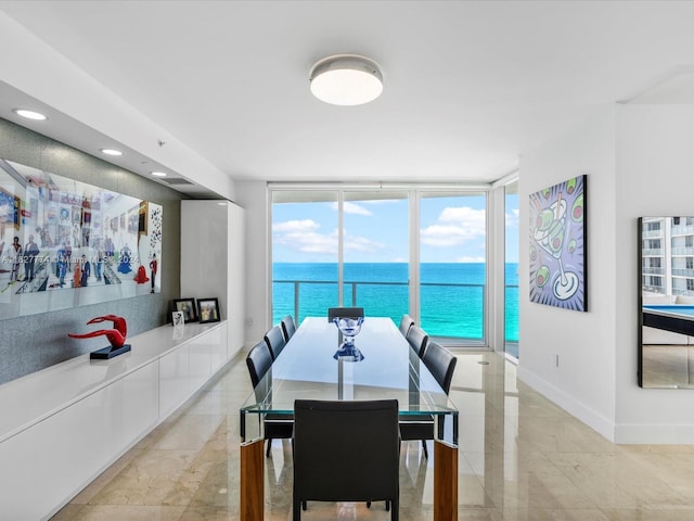 dining area featuring a wall of windows and a water view