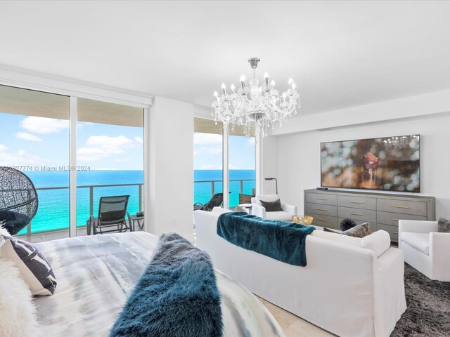 bedroom with expansive windows, a notable chandelier, and access to outside