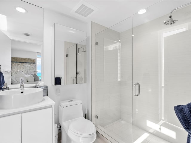 bathroom with vanity, toilet, and a shower with door