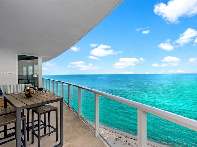 balcony featuring a water view and a beach view