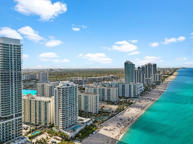 birds eye view of property with a water view and a beach view