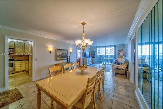 dining space with light tile patterned floors, ornamental molding, baseboards, and an inviting chandelier