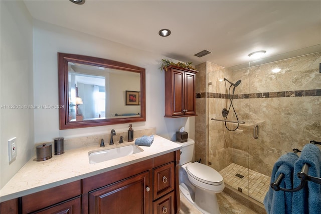 bathroom with visible vents, vanity, a shower stall, and toilet