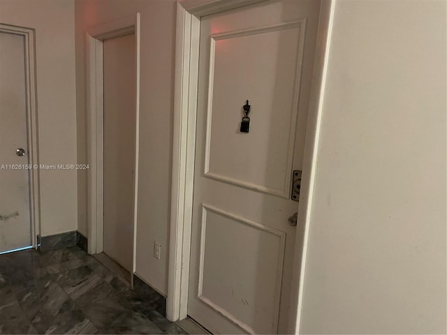 hall with dark tile patterned flooring