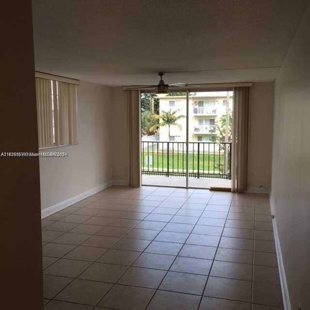 empty room featuring tile patterned flooring and ceiling fan