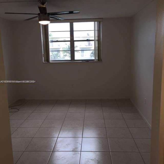 empty room with tile patterned floors and ceiling fan