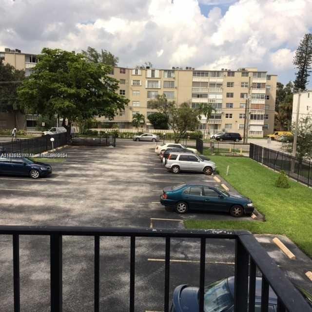 view of parking with a yard