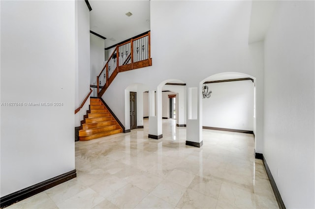 foyer entrance featuring a high ceiling and tile patterned floors