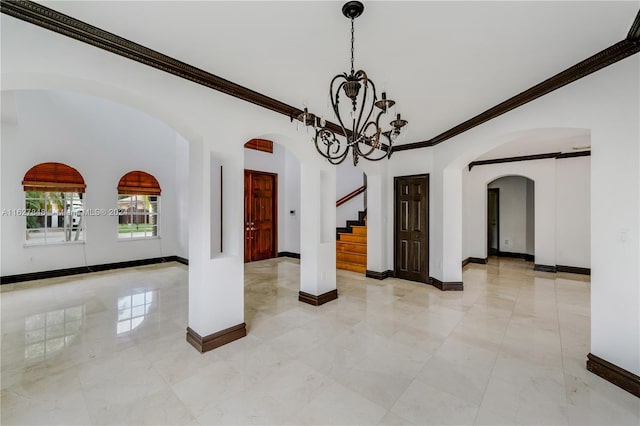 tiled spare room with an inviting chandelier and ornamental molding