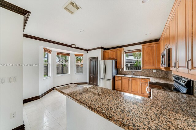 kitchen with decorative backsplash, light tile patterned floors, sink, dark stone countertops, and stainless steel appliances