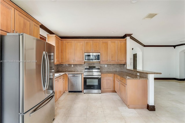 kitchen with backsplash, dark stone countertops, light tile patterned floors, stainless steel appliances, and kitchen peninsula