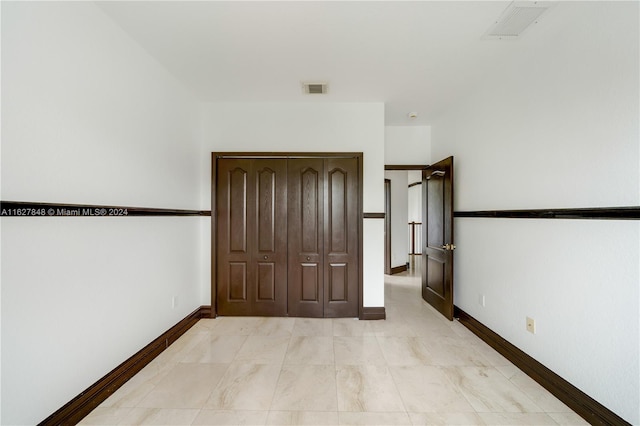 unfurnished bedroom with a closet and light tile patterned floors