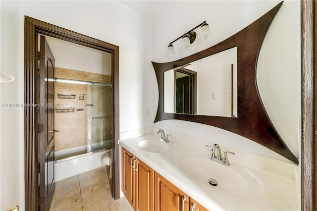 full bathroom with shower / bath combination with glass door, toilet, double vanity, and tile patterned flooring