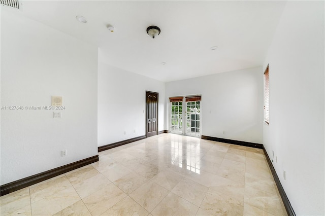 tiled spare room with french doors