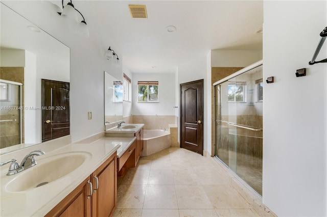 bathroom with tile patterned flooring, double vanity, and plus walk in shower