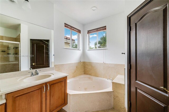 bathroom with vanity and shower with separate bathtub