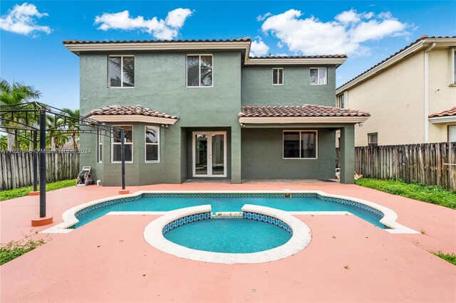 exterior space featuring french doors, an in ground hot tub, and a patio